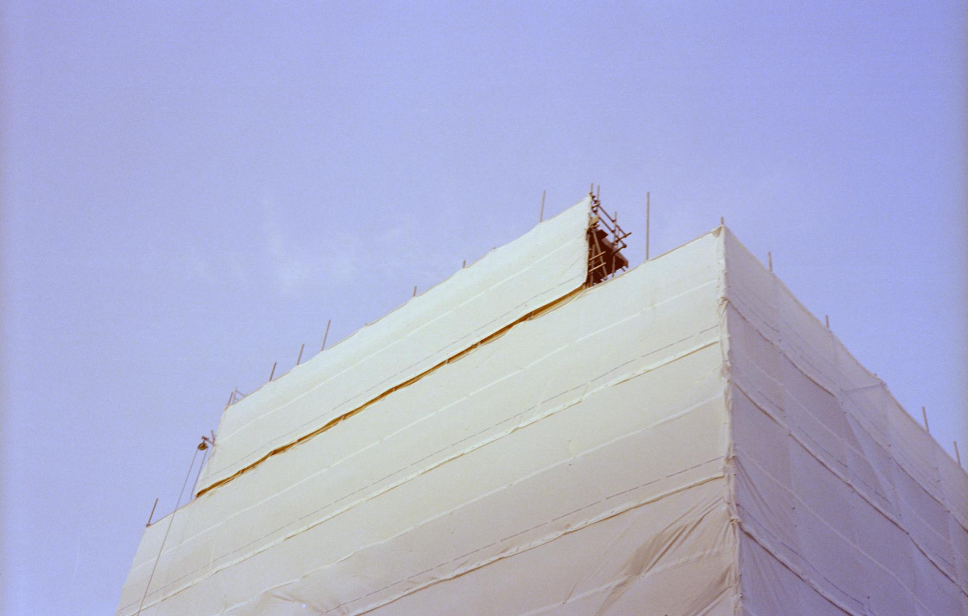 High-rise building with construction shrink wrap and Seattle scaffolding protection during winter